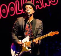Bruno Mars singing to the crowd with his guitar. 

(image: Creative Commons)